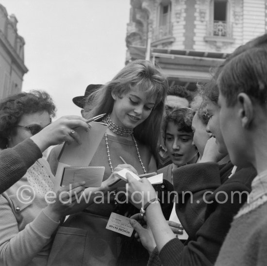 Brigitte Bardot, signing set cards. Nice 1956. - Photo by Edward Quinn