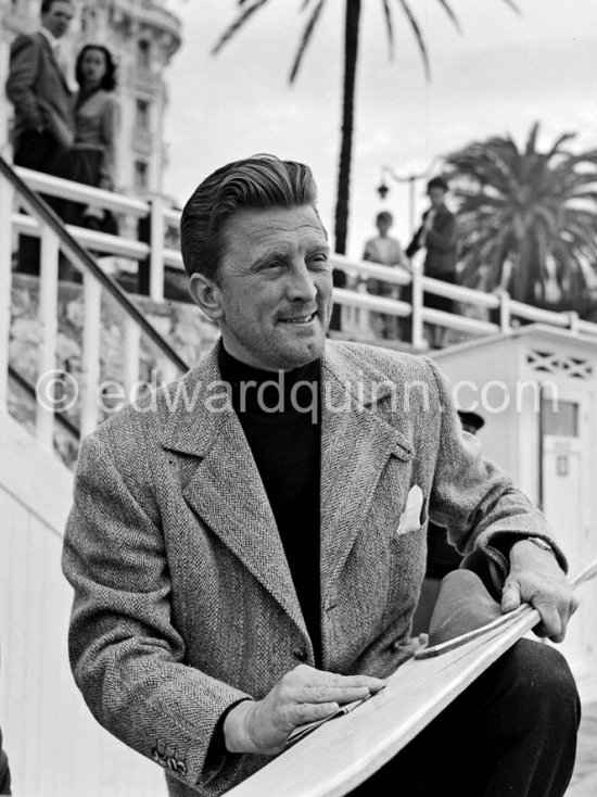 Kirk Douglas with his surfboard in front of the Carlton Hotel. - Photo by Edward Quinn