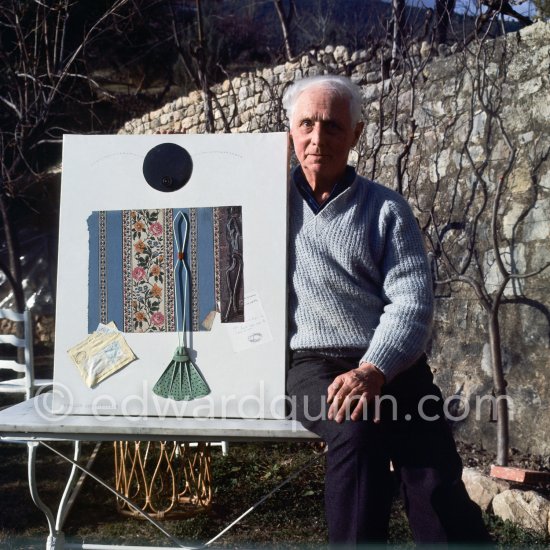 Max Ernst and Dorothea Tanning in the garden of her house at Seillans 1966. He holds the painting Schmetterling-Steuerzahler (papillon contribuable), for which he has used a piece of wallpaper, a flybat and a note from the income tax officer concerning his income tax return. - Photo by Edward Quinn
