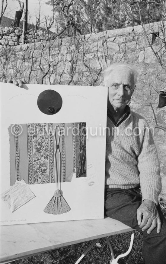Max Ernst in the garden of her house at Seillans 1966. He holds the painting Schmetterling-Steuerzahler (papillon contribuable), for which he has used a piece of wallpaper, a flybat and a note from the income tax officer concerning his income tax return. - Photo by Edward Quinn