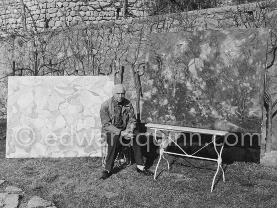 Max Ernst in the garden of his home with "La fête à Seillans"), 1964. and on the table the first version of "Der letzte Wald" ("La dernière forêt"), 1960-1969. Seillans 1966. - Photo by Edward Quinn