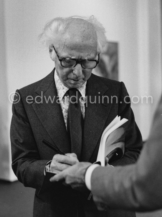 Max Ernst signing a catalogue at the opening of the exhibition "Dorothea Tanning: Oeuvre" (retrospective), Centre National d\'Art Contemporain CNAC, Paris, May 28 - July 8, 1974. - Photo by Edward Quinn
