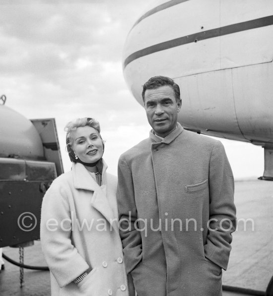Zsa Zsa Gabor and Porfirio Rubirosa in front of the private plane of Porfirio Rubirosa, a converted North American B-25 Mitchell, at Cannes Airport in 1954. North American B-25 Mitchell B-25H-1NA 43-4432 (N10V). See https://bit.ly/2XS08rs. Was as "Berlin Express" in the 1970 movie Catch-22. Today at Eagle Hangar, EAA Aviation Museum, Oshkosh. - Photo by Edward Quinn