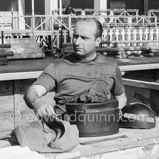 Juan Manuel Fangio with his helmet box. Monaco Grand Prix 1957. - Photo by Edward Quinn