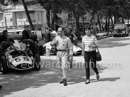 With an unconcerned smile on his face, Stirling Moss arrives with his wife Katie at the pits. Maserati (56) 250F of André Testut and Cooper-Climax F2 (34) of Ivor Bueb. Monaco Grand Prix 1959. - Photo by Edward Quinn