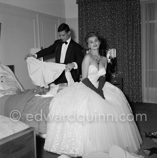 Sophia Loren in her Carlton Hotel room during the Cannes Film Festival wearing an evening gown designed by Emilio Schuberth, 27 April 1955. - Photo by Edward Quinn