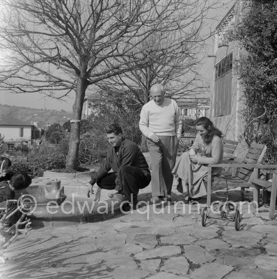 Pablo Picasso, Françoise Gilot and Paulo Picasso in the garden of La Galloise. With tricycle. Vallauris 1953. - Photo by Edward Quinn