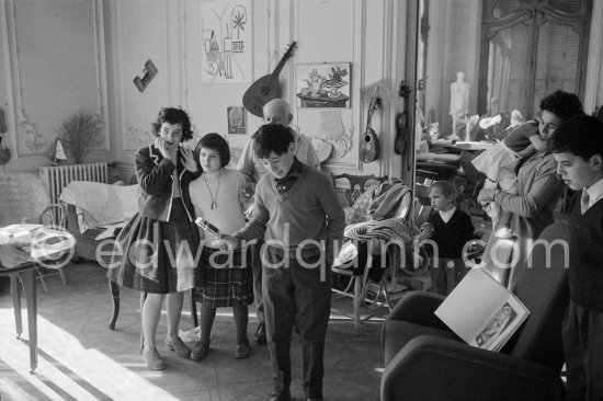 Jacqueline pulls a surprise cracker with Claude Picasso. Behind her daughter Catherine Hutin, Paloma Picasso and Pablo Picasso looking on. Right the Dominguin children with Inès Sassier and Gérard Sassier. La Californie, Cannes 1959. - Photo by Edward Quinn