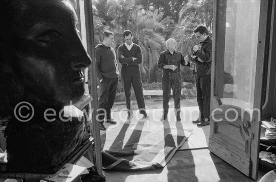 Pablo Picasso discussing with the expert Pierre Baudouin the project for a tapestry designed by him. Luis Miguel Dominguin and at left Paulo Picasso. La Californie, Cannes 1959. - Photo by Edward Quinn