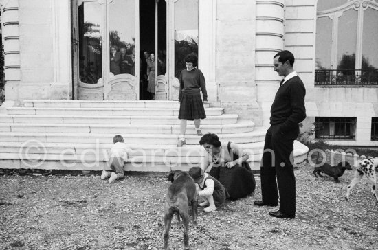 Luis Miguel Dominguin and his wife Lucia Bosè and their children Louis and Lucia with dogs Jan, Perro and Lump. Behind the door Pablo Picasso, Jacqueline, Michel Leiris, Louise Leiris. La Californie, Cannes 1959. - Photo by Edward Quinn