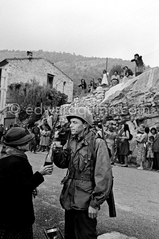Frank Sinatra on the set of the film Kings Go Forth in the village of Tourette-sur-Loup, 1957. Sinatra needed an old lady to partner him in this scene. The villager Marie Isnard, who had never been to the cinema in her life, learned her lines and got through the dialogue very successfully. Sinatra\'s lines were: \'Vive General de Gaulle, Vive les Folies-Bergere", about the only French he knew. Tourrettes-sur-Loup 1957. - Photo by Edward Quinn