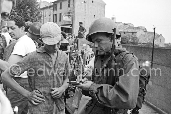 Lt. Sam Loggins (Frank Sinatra) signing autographs on the set of the film "Kings Go Forth" in the village of Tourrettes-sur-Loup, 1957. - Photo by Edward Quinn