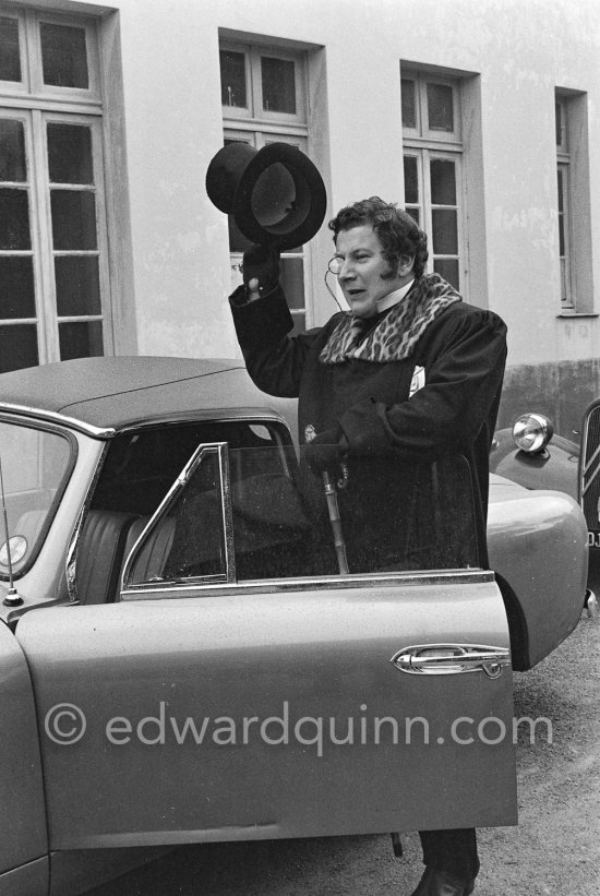 A top-head salute of Peter Ustinov at the Studios de la Victorine during filming of "Lola Montès". Nice 1955. Car: 1955 Aston Martin DB 2/4 Drophead coupé - Photo by Edward Quinn