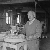 Pablo Picasso using a potter's wheel to examine a finished ceramic jug at the Madoura pottery Vallauris. 23.3.1953. - Photo by Edward Quinn