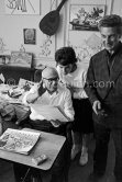 Pablo Picasso, Catherine Hutin and Jacques Frélaut, printer in Vallauris, viewing photos by Edward Quinn, which the latter brought as a gift. On the right Jacques Frélaut, printer In Vallauris. La Californie, Cannes 1961. - Photo by Edward Quinn