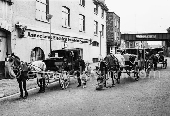 The cab rank at Beresford place. Dublin 1963. Published in Quinn, Edward. James Joyces Dublin. Secker & Warburg, London 1974. - Photo by Edward Quinn