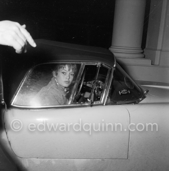 Brigitte Bardot in front of Hotel Negresco. Many people think Bardot owned a Lancia B24. It\'s not true. She loved Roger Vadim\'s car (her husband who used his car in the movie "Et Dieu créa la Femme") and commissioned a special bodied one but she never took possession of it. In front of Hotel Negresco, Nice 1955. Car: Lancia Aurelia B24 Spider America Cabriolet 1955. - Photo by Edward Quinn