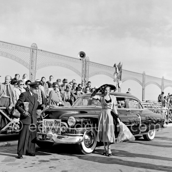 Concours d’Elégance Automobile. Cadillac 1951 Fleetwood Sixty Special Sedan N° 61 of Mr. Dewals, Grand Prix for American Manufacture, with Mlle Georgette Lefèvre who won price for "plus harmonieux ensemble" (most harmonious ensemble). Cannes 28.3.1951. - Photo by Edward Quinn