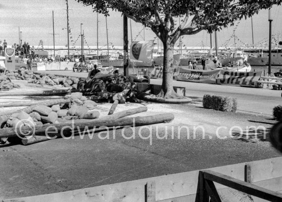 The wreck of Moss\' (18) Vanwall VW3/4 in the barriers. In the background Wolfgang von Trips, (24) Ferrari 80I, passes. Monaco Grand Prix 1957. The incident happend in lap 4 of the 1957 Monaco Grand Prix after leader Stirling Moss "lost" his Vanwall in the chicane. - Photo by Edward Quinn