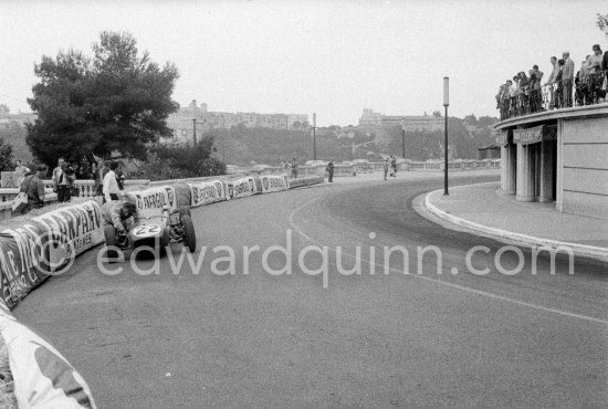 Innes Ireland pushes his N° 22 Lotus 18 uphill and right around the twisting Monaco circuit so that he can finish the race. His effort was repaid when he got 9th place and one point for the world championship. Monaco Grand Prix 1960. - Photo by Edward Quinn