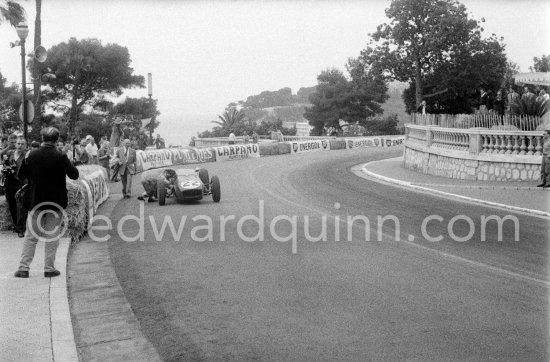 Innes Ireland pushes his N° 22 Lotus 18 uphill and right around the twisting Monaco circuit so that he can finish the race. His effort was repaid when he got 9th place and one point for the world championship. Monaco Grand Prix 1960. - Photo by Edward Quinn