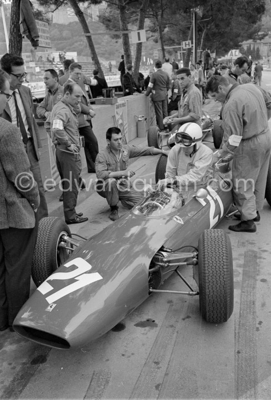 Stirling Moss (left) with John Surtees, (21) Ferrari 158. On the left Mauro Forghieri. Monaco Grand Prix 1964. - Photo by Edward Quinn