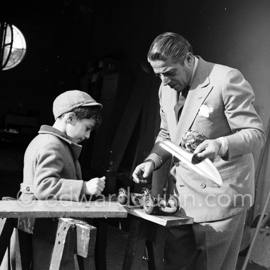 Aristotle Onassis with his son Alexander at Château de la Croë. He seems to be preparing his son\'s toy car. Cap d’Antibes 1954. - Photo by Edward Quinn