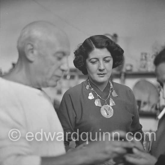 Pablo Picasso with Madame Paule de Lazerme (she had an affair with Pablo Picasso for some months) who wears a necklace designed by Pablo Picasso, made with the help of the Vallauris dentist Dr. Chatagnier. In front of the studio Le Fournas, Vallauris 1953. - Photo by Edward Quinn