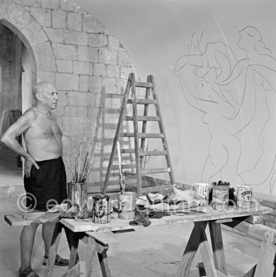 Pablo Picasso working on the "War and Peace study" drawings on the wall of Chapelle de la Paix (or Temple de la Paix) for the documentary film of Luciano Emmer. (The panels of War and Peace of 1952 were away on exhibition). Vallauris 1953. - Photo by Edward Quinn