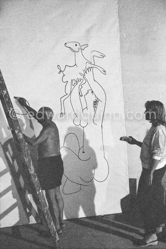 Pablo Picasso working on a bucolic pastoral scene on drawing paper which was to serve as background for the film "Le mystère Picasso". Maya Picasso on the right. Nice, Studios de la Victorine 1955. - Photo by Edward Quinn