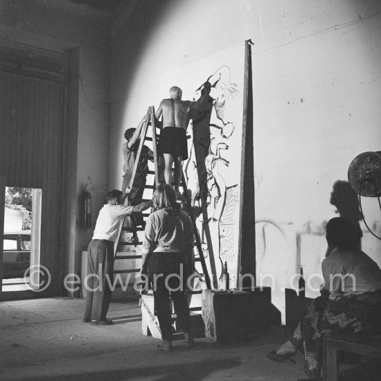 Pablo Picasso working on a bucolic pastoral scene on drawing paper which was to serve as background for the film "Le mystère Picasso". Maya Picasso and Jacqueline on the right. Nice, Studios de la Victorine 1955. - Photo by Edward Quinn