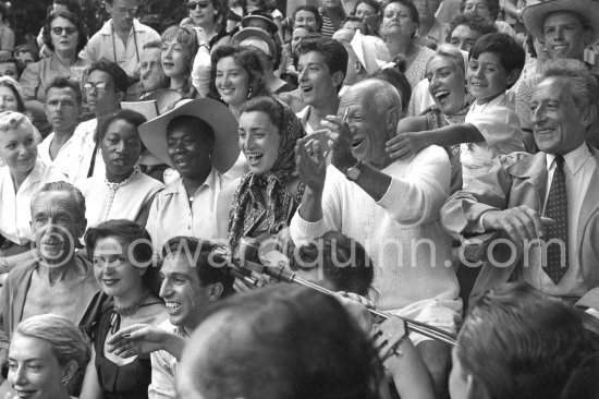 Amused applause. From left: Jacques-Henri Lartigue, photographer, his wife Florette, Javier Vilató, Jacqueline, Pablo Picasso, Jean Cocteau. Behind them Maya Picasso and Claude Picasso. Vallauris 1955. Interview RTF: http://www.ina.fr/audio/P13108794/corrida-a-Vallauris-ete-1955.-audio.html - Photo by Edward Quinn