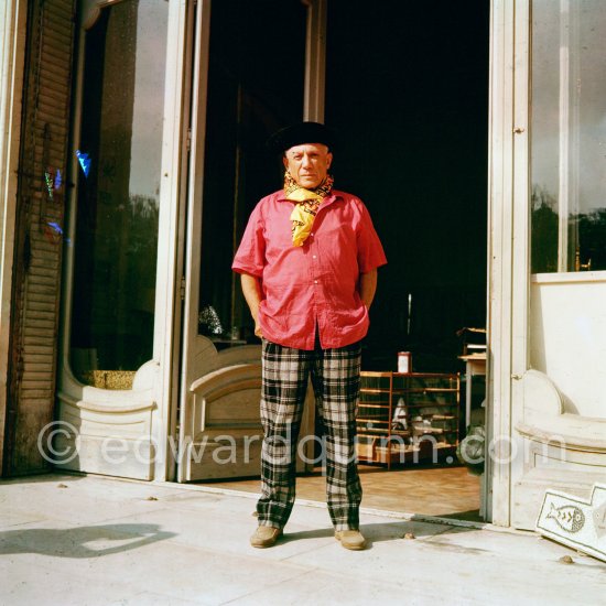 Pablo Picasso in a whimsical costume. Among other things, he has on a bullfighter’s jacket, given to him by his friend, the famous matador Dominguin. On the floor a mosaic Hjalmar Boyesen executed after a Pablo Picasso design. In front of the garden gate at La Californie. Cannes 1956. - Photo by Edward Quinn