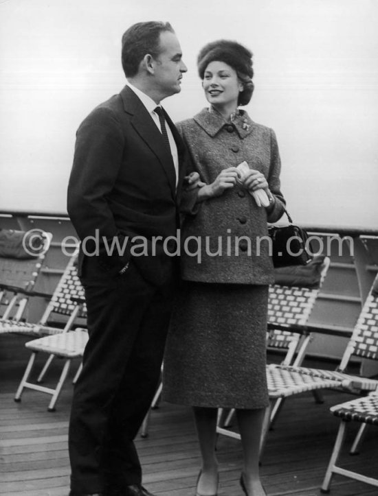 Rainier, Prince of Monaco and Princess Grace. On board the liner "Constitution", arriving from the U.S. after a six week trip to the United States. Monaco 1956. (Grace Kelly). She wears a tailored suit with a gently flared jacket and the Cartier brooch in the shape of a poodle that was one of her favorite pieces of jewelry. - Photo by Edward Quinn