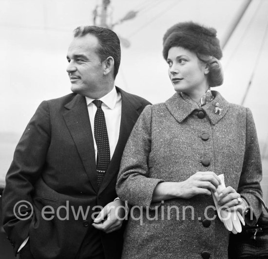 Rainier, Prince of Monaco and Princess Grace. On board the liner "Constitution", arriving from the U.S. after a six week trip to the United States. Monaco 1956. (Grace Kelly). She wears a tailored suit with a gently flared jacket and the Cartier brooch in the shape of a poodle that was one of her favorite pieces of jewelry. - Photo by Edward Quinn