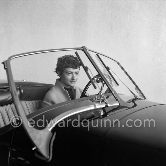 Françoise Sagan evaluating a Jaguar XK120 at the showroom of a Jaguar dealer in Cannes 1954. - Photo by Edward Quinn