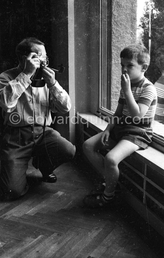 George Simenon at his Villa Golden Gate taking pictures of his son Jean with his Leica M3. Cannes 1955. - Photo by Edward Quinn