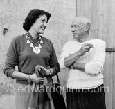 Pablo Picasso with Madame Paule de Lazerme (she had an affair with Pablo Picasso for some months) who wears a necklace designed by Pablo Picasso, made with the help of the Vallauris dentist Dr. Chataignier. In front of the studio Le Fournas, Vallauris 1953. - Photo by Edward Quinn