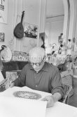 Pablo Picasso and Jacqueline viewing a book about Bernard Palissy, French potter of the 16th century. La Californie, Cannes 1957. - Photo by Edward Quinn